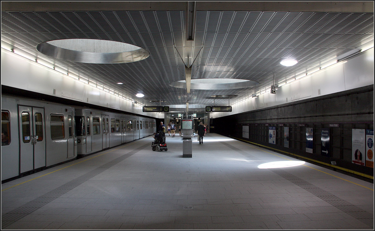 Mit Tageslicht -

Die U2-Station Messe Prater liegt flach unter der Oberfläche. Runde Oberlichter lassen Tageslicht auf den Bahnsteig fallen. Im Anschluss an diese Station gelangt die U2 an die Oberfläche und wird ihren weiteren Weg über bis zur Endstation fast durchgehend Hochbahn zurücklegen. Die Grautöne der Station bilden eine Einheit mit dem Silbergrau des Zuges.

03.06.2015 (M)