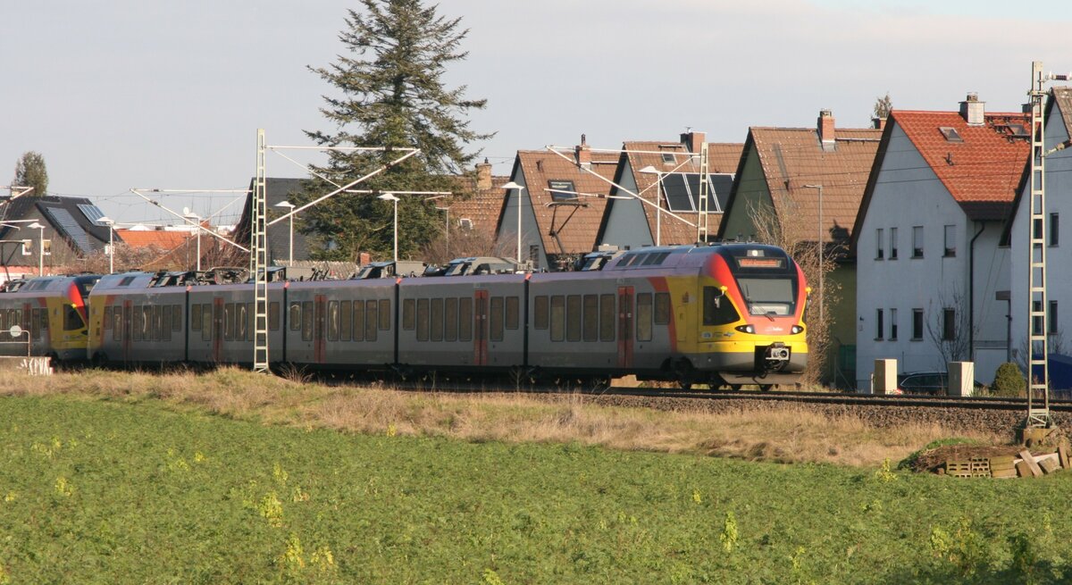 Mit Teleobjektiv habe ich am 10.1.2021 dieses HLB FLIRT-Doppel in Karben fotografieren, wie es gerade als RE98/99 nach Frankfurt(Main) Hbf den Haltepunkt passiert.