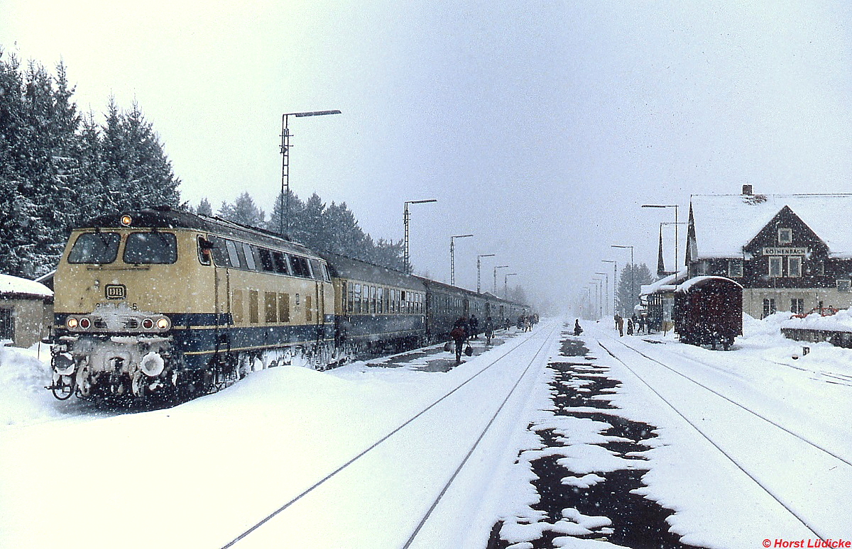 Mit einer unbekannten 218 an der Spitze hält ein schweizer Schnellzug im Februar 1983 in Röthenbach