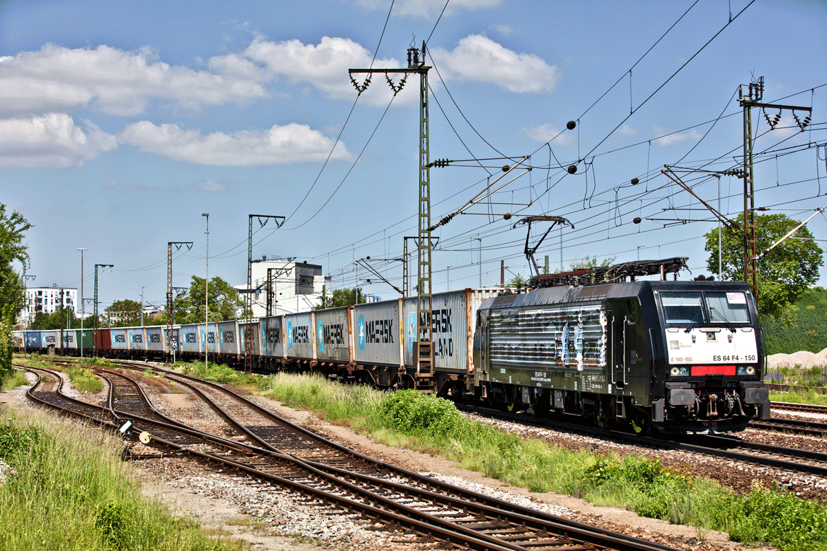 Mit wehenden Fahnen fährt die ES 64 F4 150 mit einem Seecontainerzug in Regensburg vorüber.Bild vom 27.5.2017