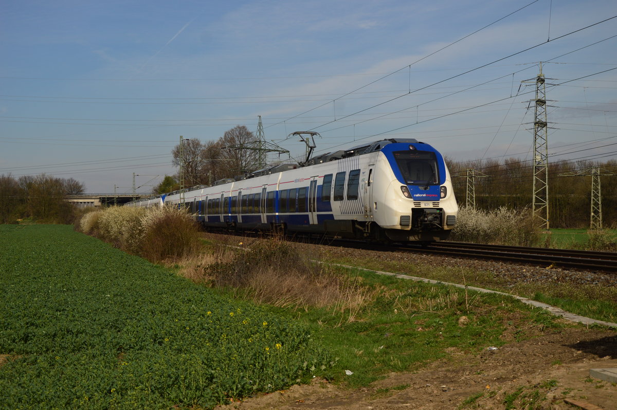 Mit zehn Minuten Plus kommt hier ein RE7 der NX bei Neuss Weißenberg, geführt wird der Zug vom 9442 871 gen Münster. 3.4.2016