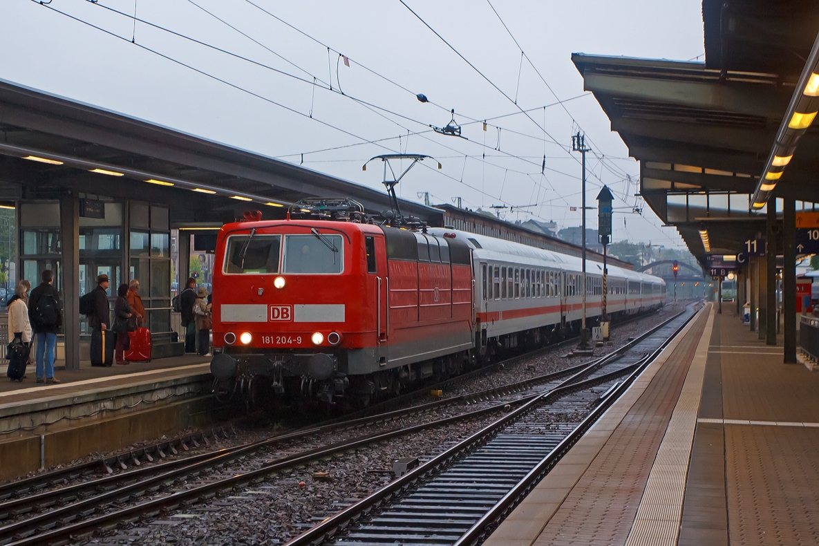 Mit Zehnmentiger Versptung fhrt um 9:17 bei Regen die 181 204-9 mit dem IC 133  Ostfriesland  (Luxembourg - Trier - Koblenz - Kln - Norddeich Mole) in den Hbf Trier ein.  

Noch entlang der Mosel wird der IC bis Koblenz von dieser Zweisystemlokomotive gezogen, in Koblenz wird dann am anderen Zugende dann meist eine 101er angehangen, die den IC dann bis  Norddeich Mole zieht.
Die 181.2er bleiben dann, fr anderen Gegenzug, in Koblenz stehen. 

Von der Lokbaureihe 181.2 wurde 1974 bis 1975 insgesamt 25 Maschinen speziell fr den grenzberschreitenden Verkehr nach Frankreich und Luxemburg beschafft. Diese wurden von Krupp (Mechanischer Teil) und AEG (Elektrischer Teil) gebaut und geliefert. Zudem waren bereit 1966 vier Vorserienlok E 310 (BR 181.0 und 181.1) von Krupp und AEG gebaut worden.

