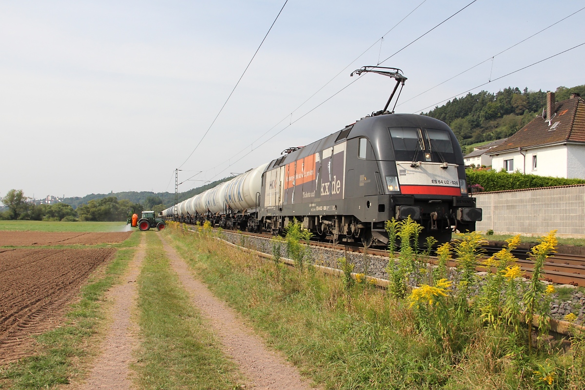 Mit ziemliche schäbiger HKX-Banderole bespannte 182 526 (ES 64 U2-026) am 24.08.2013 einen Kesselwagenzug in Fahrtrichtung Norden. Aufgenommen in Ludwigsau-Friedlos.