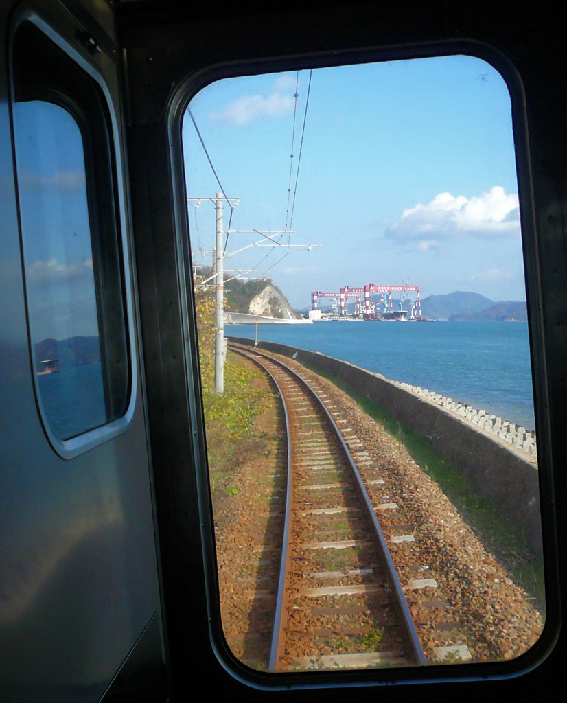 Mit Zügen der Serie 105 der Inlandsee entlang: Blick aus dem Zug 105-19 auf die Schiffswerften von Saizaki, 6.Dezember 2010. 