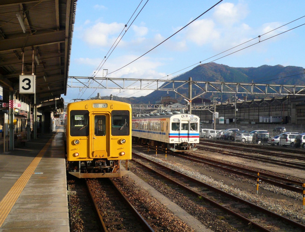 Mit Zügen der Serie 105 der Inlandsee entlang: In Hiro an der Kure-Linie begegnen sich der dreitürige Steuerwagen KUHA 104-19 im neuen gelben Anstrich und der viertürige ehemalige Tokyo-S-Bahnzug KUHA 105-10, 6.Dezember 2010.  