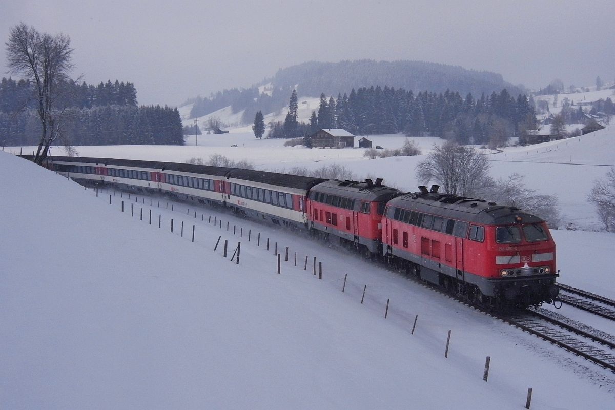 Mitte Mrz und es schneit schon wieder. 218 400-0 und eine weitere 218er mit den Wagen des EC 196 von Mnchen nach Bregenz kurz nach Oberstaufen, Nhe Zell (15.03.2013).