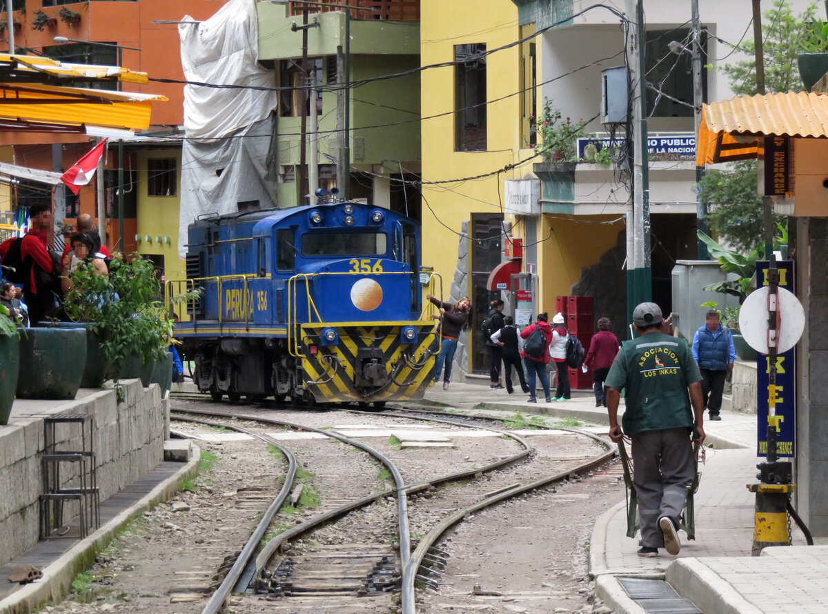 Mitten im St�dtchen Aguas Calientes ist nachmittags die Diesellok Nr. 356 abgestellt. Eine junge Dame l�sst sich auf dem Trittbrett fotografieren. Aguas Calientes, 15.7.2015