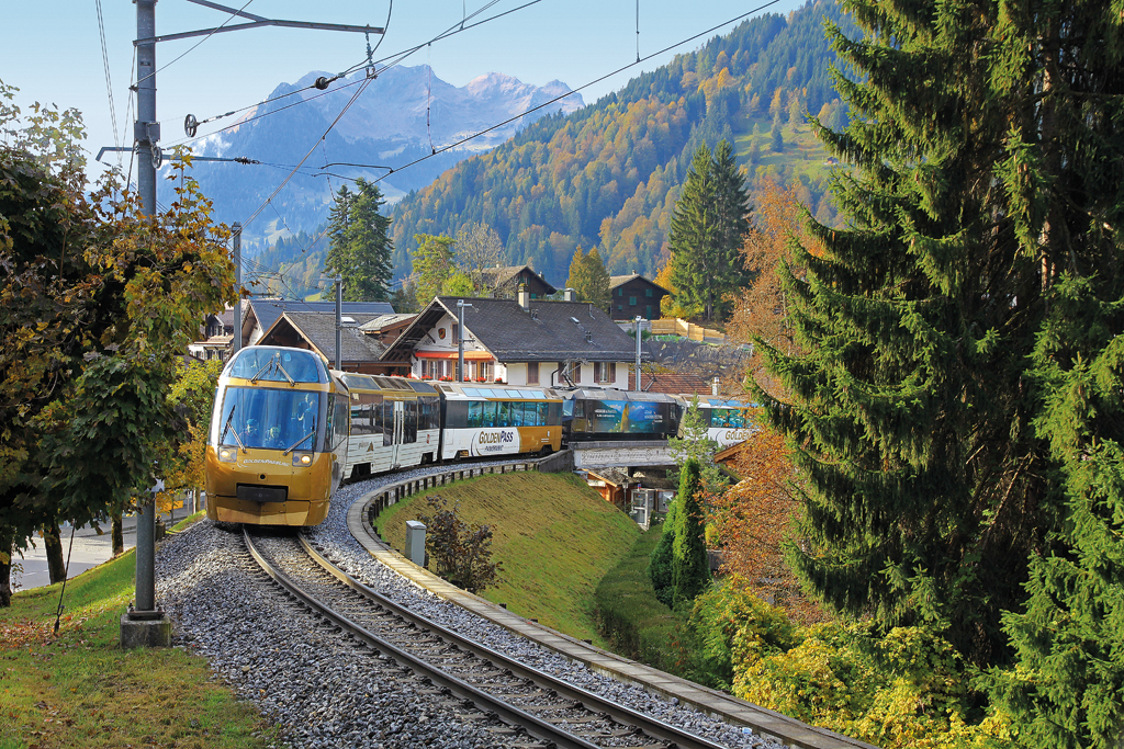 MOB Goldenpass Panoramic mit Ge 4/4 in Zugsmitte hat soeben den Bahnhof Gstaad verlassen und fährt nun in Richtung Zweisimmen, 19. Okt. 2016, 11:09
