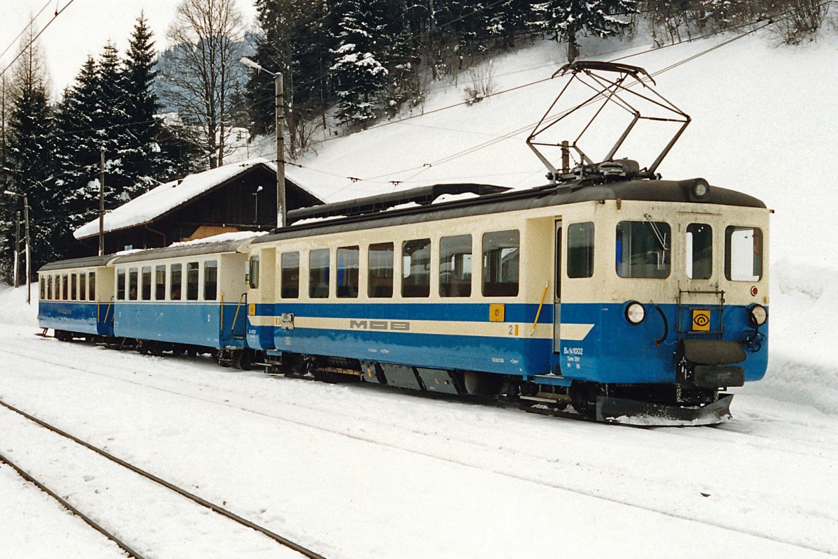 MOB: Regionalzug Zweisimmen-Gstaad bestehend aus dem Be 4/4 1002 (ex BA ABe 4/4 4) und zwei 2 B4 mit oP der Serie 203-206, die aus Umbauten entstanden sind. Diese eher seltene  Zugszusammenstellung wurde im Februar 1990 in Gstaad auf einem Bilde verewigt.
Foto: Walter Ruetsch 