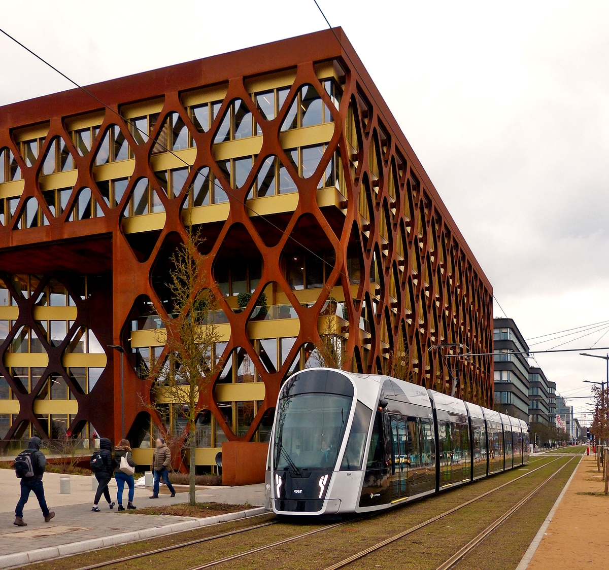 Moderne Tram vor moderner Architektur - Die Tram fgt sich optisch perfekt in die Stadt ein: Auf dem Kirchberg-Plateau fhrt die Tram auf ihrer gesamten Strecke auf begrnten Gleisen und verschnert somit das Stadtbild. 12.12.2017 (Hans)

Am 10.12.2017 wurde eine Teilstrecke der Straenbahn Luxtram S.A. offiziel in Betrieb genommen. Von der Haltestelle Luxexpo verluft die Trasse paralell mit der Avenue John F. Kennedy in Stadtteil Kirchberg bis zur provisorischen Endstation Rout Brck-Pafendall. 

