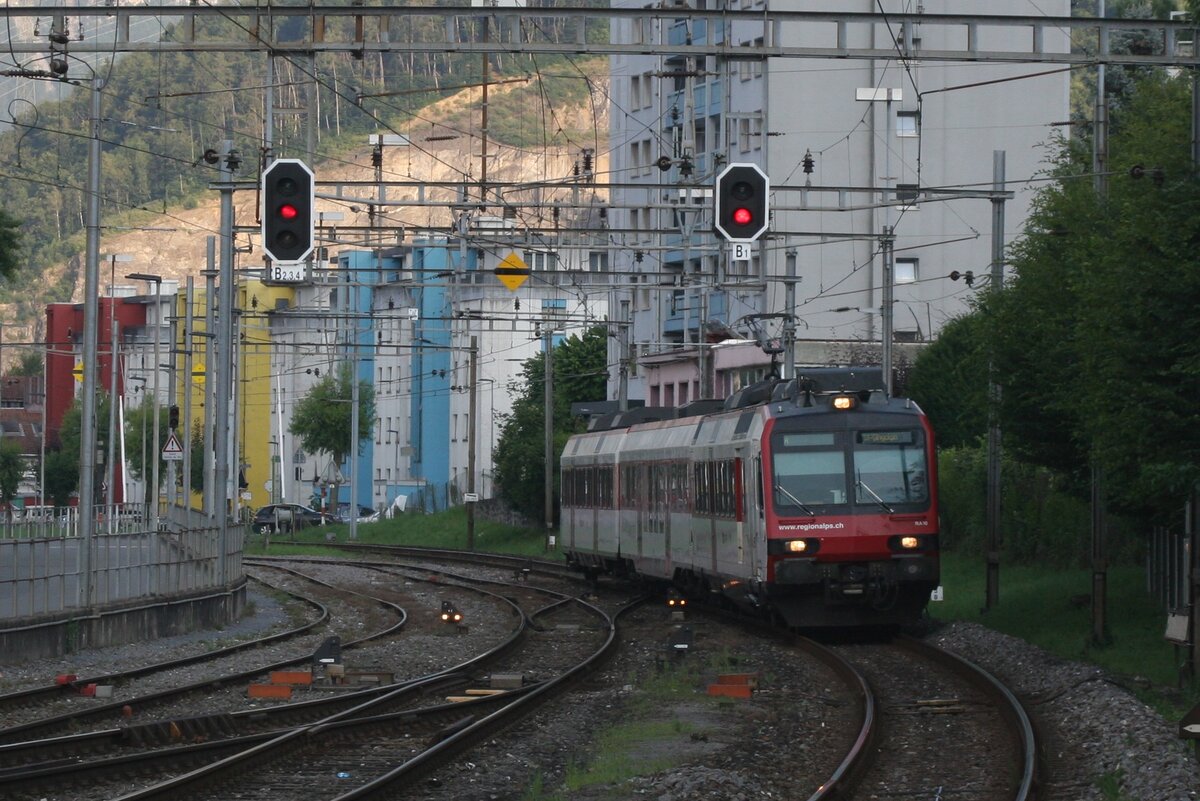 Monthey liegt inmitten mehrerer 4000er, die die Sonne schon ziemlich früh am Abend bedecken, auch im Hochsommer. Am 19. Juli 2021 um 19:43 Uhr fährt der Regionalzug aus St - Maurice nach St - Gingolph bereits im Schatten im Bahnhof Monthey CFF ein. Der Triebzug ist der RBDe 560 410 der Region Alps, einer Tochtergesellschaft der SBB, die die Regionalzüge im Kanton Wallis betreibt.

Monthey CFF, 19.07.2021