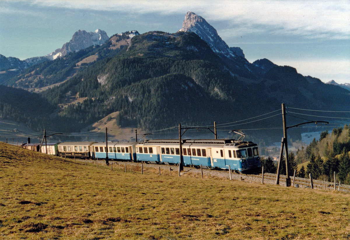 Montreux-Oberland Bernois Bahn/MOB.
Gemischter Regionalzug mit dem ABDe 8/8 4004  Fribourg  oberhalb Gstaad auf der Fahrt nach Zweisimmen im Sommer 1979.
Während diesen Jahren hatten auch die Westschweiz sowie das Berner Oberland ihr  BLAUES BÄHNLI .
Foto: Walter Ruetsch
