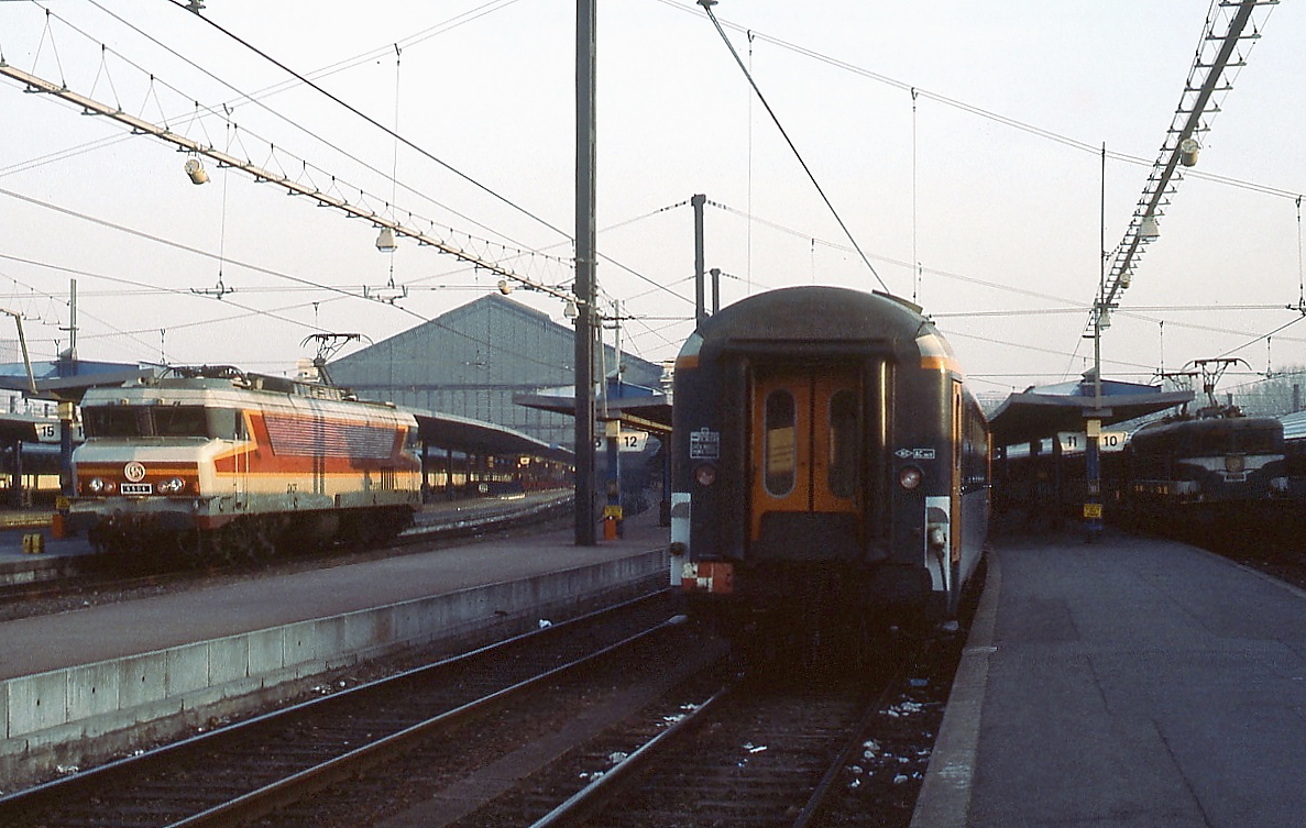 Morgenstimmung im Gare d'Austerlitz in Paris im April 1984: Während eine CC-6500 aus dem Bahnhof fährt, wartet der Sud-Express nach Lissabon noch auf seine Lokomotive, rechts im Schatten ist eine BB-9200 erkennbar