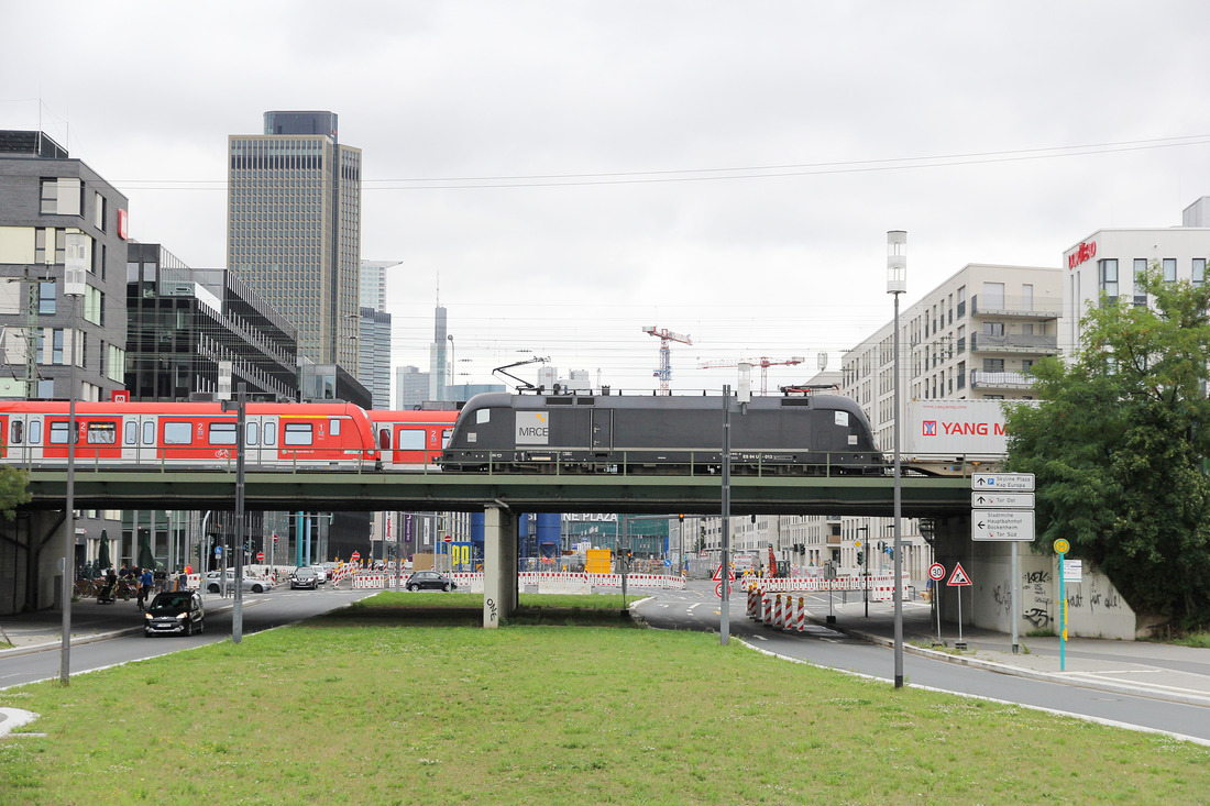 MRCE ES 64 U2-013 begegnet im Bereich des Frankfurter Europaviertels zwei Zügen der S-Bahn Rhein-Main.
Aufnahmedatum: 12. August 2017