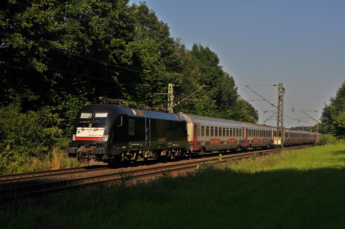 MRCE ES 64 U2-034 (182 534), vermietet an OLA, befindet sich am Abend des 03.07.14 zwischen Bohmte und Ostercappeln mit dem verspäteten aus SNCB/NMBS-Wagen gebildeten HKX 1804 auf der Fahrt von Hamburg-Altona nach Köln Hbf. 
