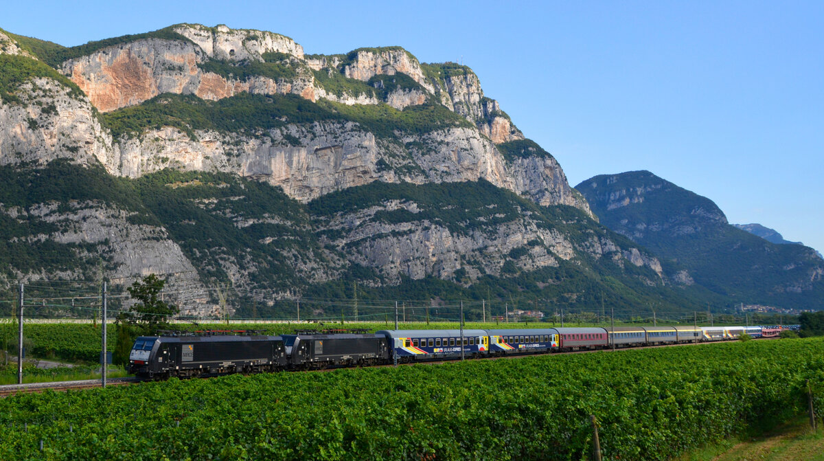 MRCE ES64 F4 009 und 189 938-4 rollen mit dem URLAUBS-EXPRESS UEx 1395 von Hamburg-Altona nach Verona pünktlich und mit freundlichem Pfiff bei Dolcé durch das Tal der Etsch. 28.08.2021