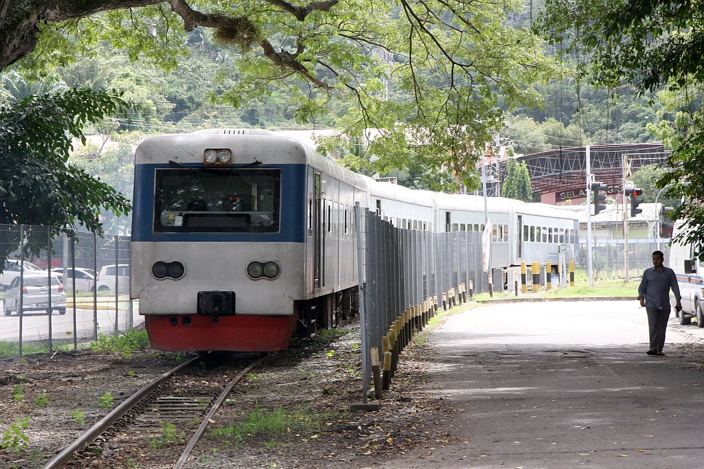 Nach der Ankunft als PU 506 (Beaufort - Sembulan) fährt die Garnitur als Leerpersonenzug die 1,75 Km zurück zur Stesen Tanjung Aru zur Hinterstellung. - Im Bild vom am 09.Februar 2025 dieser Leerpersonenzug gleich nach der Stesen Sembulan (ehemals Sekretariat) mit dem JKNS 8903-1 als letztes Fahrzeug.