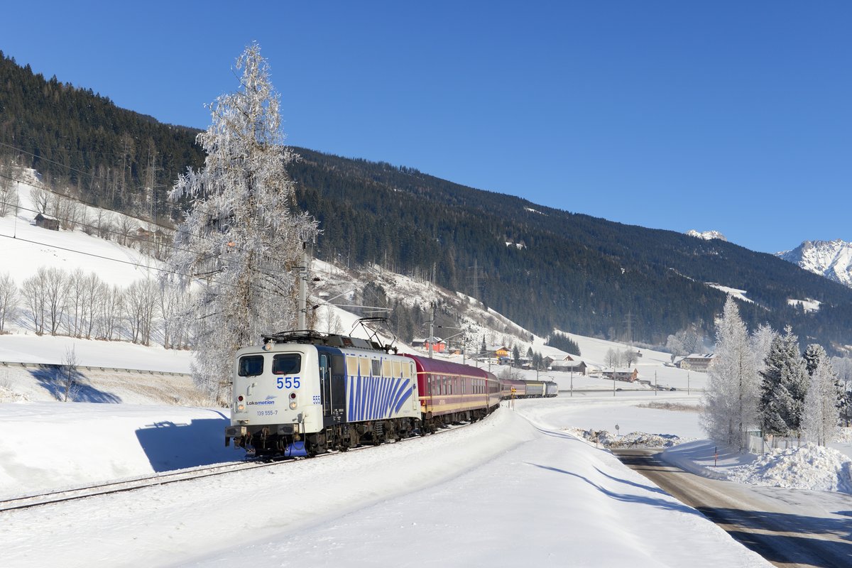 Nach Ankunft in Schladming fährt der Alpen Express als Lp 85104 zurück nach Bischofshofen. Dort wird der Wagenpark hinterstellt, behandelt und gesäubert. Am 28. Januar 2017 erwartete ich diese Leistung zusammen mit zahlreichen anderen Fotografen bei Radstadt. Die angezuckerten Bäume setzten hierbei einen schönen winterlichen Akzent. Auch hier wurde wiederum das Zusammenspiel zwischen Einheits-E-Lok und Vectron getestet, diesmal war 139 555 an der Zugspitze und 193 772 arbeitend am Zugschluss.
 