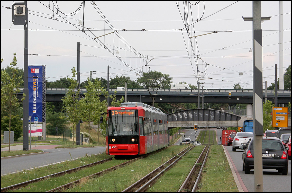 Nach Bewältigung eines kurzen Anstieges -

Ein Straßenbahnzug auf der Bremer Linie 3 kurz vor der Haltestelle Eduard-Schöpf-Allee. Interessant das vierschienige Gleis rechts für den Gleisanschuss von Betrieben/Lagerhäusern im Hafengelände. 

22.08.2012 (M)