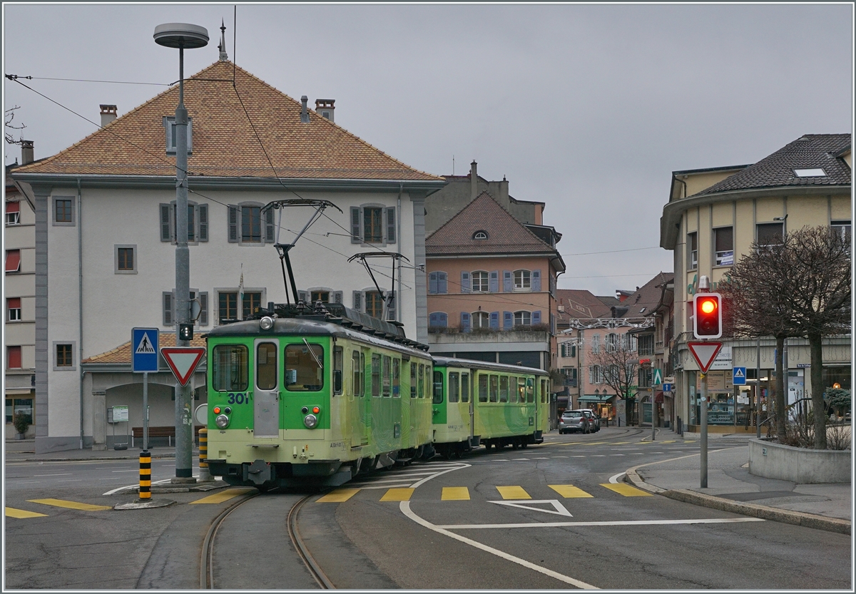Nach dem halt des TPC /A-L Regionalzug bestehend aus dem AL Bt 352 und dem schiebenden BDeh 4/4 301 in Aigle Place du Marché und der vorhergegangenen Fahrt von Aigle Dépôt A-L auf einer relafitv breiten Strasse, folgt nun die Einfahrt in die Altstadt von Aigle und damit  verbunden die anschliessende Fahrt durch eine recht enge Strasse zum Bahnhof von Aigle. 

3. Januar 2021