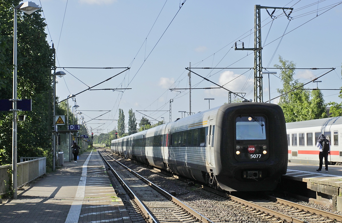 Nach dem Rückzug aus dem Kopenhagen-Verkehr kommen die IC3 der DSB nur noch mit den beiden IC-Zugpaaren aus Aarhus nach Hamburg. Am 06.07.2023 hat sich eine MF-Dreifachtraktion, vorne MFA 5077, vor kurzem in Hamburg auf den Weg gemacht, hier brummt sie mit dem morgendlichen IC 1186 durch den Bahnhof Elmshorn.