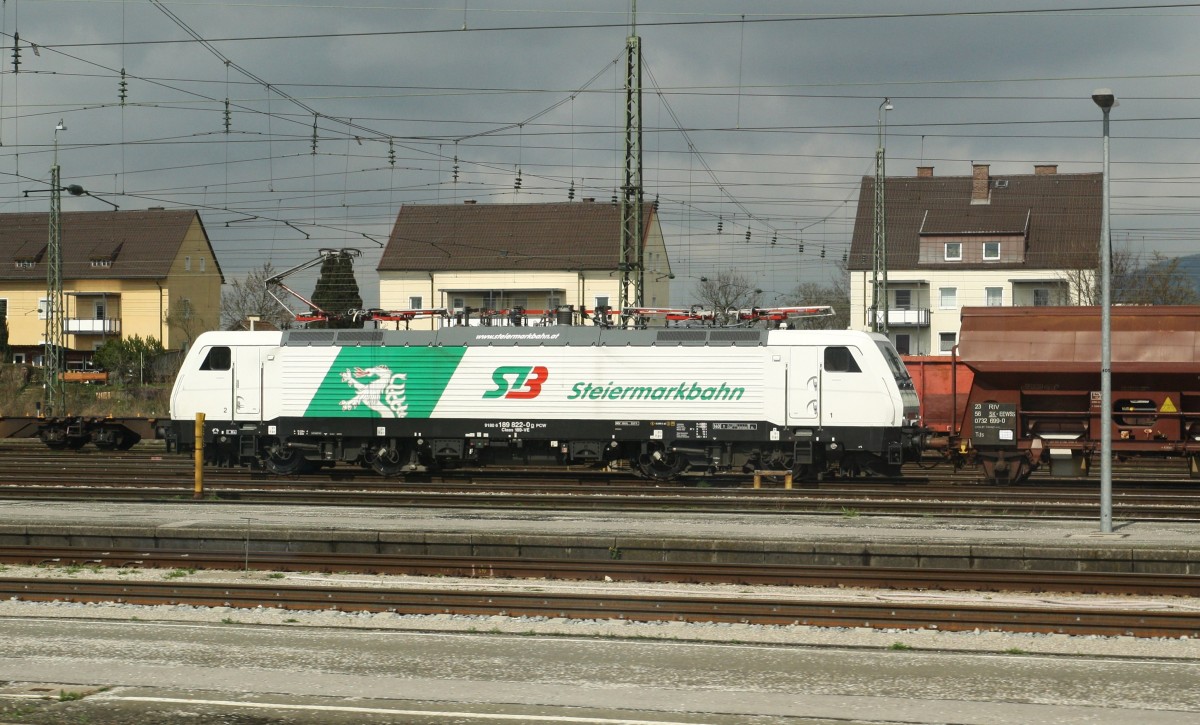Nach dem Schneetreiben auf der Strecke Rosenheim-Salzburg ist mir bei Sonnenschein in Freilassing die 189 822-0 der Steiermarkbahn begegnet. Hier aus dem IC 865 Bregenz-Wien West am 24.3.2014 fotografiert. Am Haken die BR 189 einen Schotterzug.