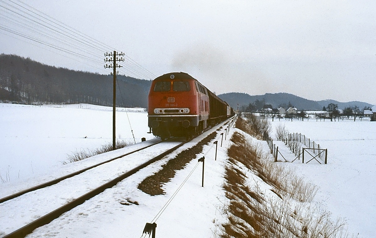 Nach dem Umsetzen in Roßberg fährt 215 061-3 am 14.02.1983 mit ihrem Güterzug auf der Württembergischen Allgäubahn weiter in Richtung Aulendorf