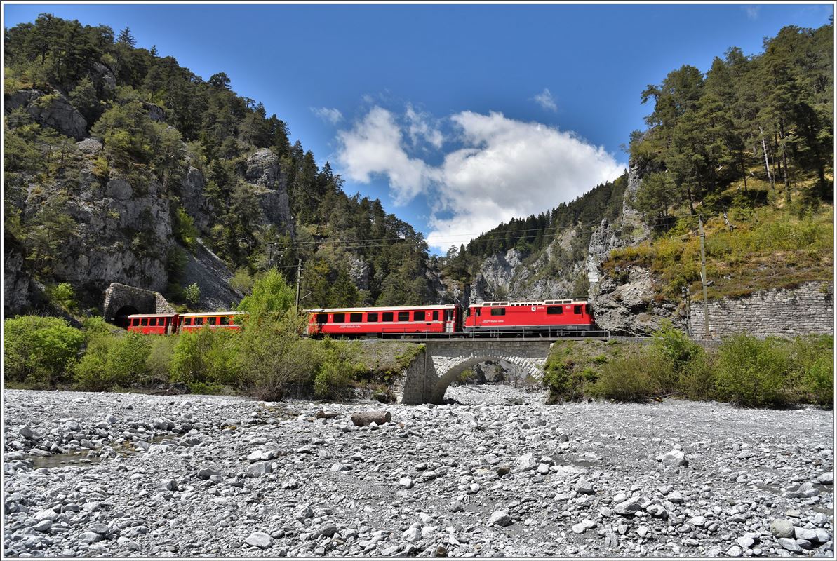 Nach dem Verlassen des 423m langen Ransuntunnels überquert der RE 1740 mit Ge 4/4 II 631  Untervaz  den Flem am Eingang zum Val Pintrun. (09.05.2017)
