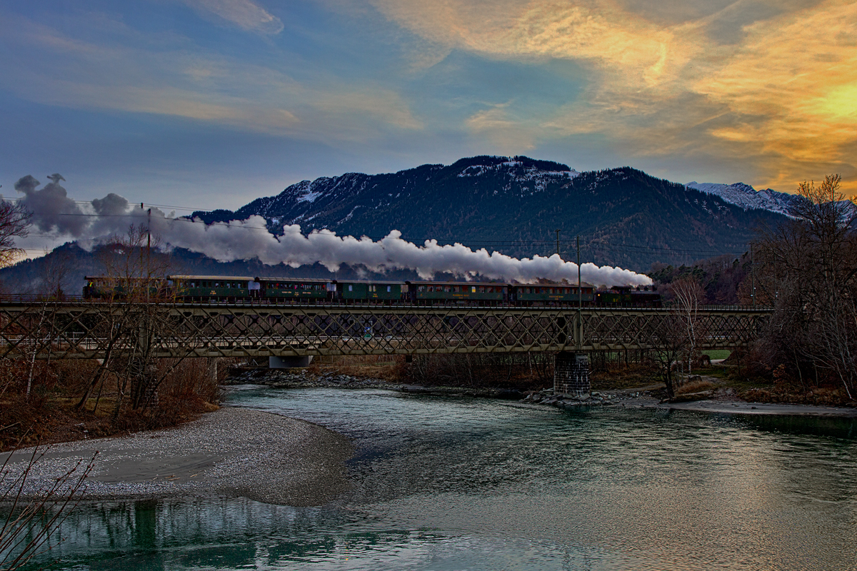 Nach dem Wasserfassen in Reichenau fährt die Dampflokomotive G 4/5 107, gebaut im Jahre 1906,beim Einnachten mit dem Cla Ferovia Sonderzug,mit dem Märlikondukteur und einer grossen Kinderschar,über die Eisenbahnbrücke in Reichenau dem Lichterland entgegen.Bild vom 13.12.2015