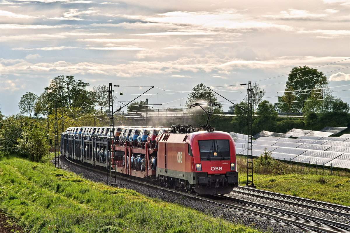 Nach einem Regenguss kommt 1116 095 mit einem Autotransportzug in Langenisarhofen vorüber.Bild 9.5.2019