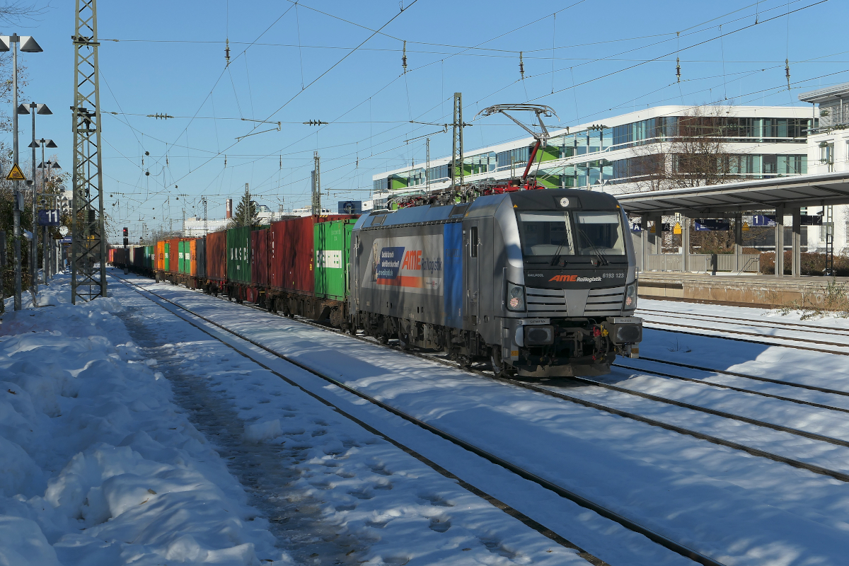 Nach den starken Schneefällen des ersten Dezemberwochenendes 2023 kam der Eisenbahnverkehr in Südbayern teilweise zum erliegen, auch die Münchner S-Bahn fuhr nicht. Aber am Donnerstag, den 7. Dezember 2023, kam der Bahnverkehr wieder in Gang, auch fuhr die S-Bahn wieder normal.
Hier führt die fast fabrikneue 6193 123 der Railpool, vermietet an den Personaldienstleister AME-Raillogistk, einen Containerzug aus Hamburg vorbei am Heimeranplatz nach München Riem. Laut der Homepage von AME wird der Verkehr in Zusammenarbeit mit DB Cargo erbracht, die Lokomotiven sind mit AME-Personal besetzt.
München Heimeranplatz, Donnerstag, 07.12.2023  