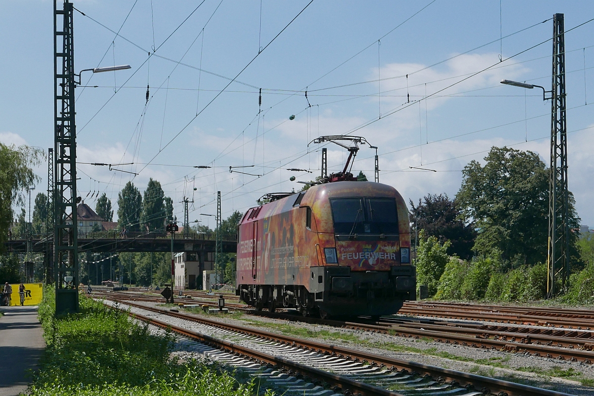 Nachdem 1016 048 die Wagen des IC 118 von Innsbruck in den Bahnhof von Lindau gezogen hatte, zwei 218er die Wagen übernommen hatten und mit diesen Richtung Friedrichshafen/Ulm abgefahren sind, war das Gleis für den Taurus mit der Werbung für den niederösterreichischen Feuerverband frei, um über den Bodenseedamm in die Abstellgruppe zu fahren (05.08.2017).