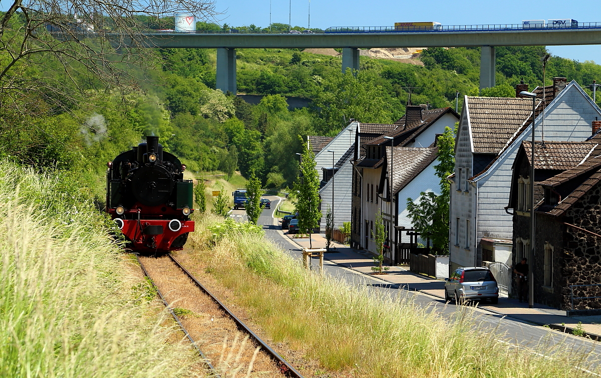 Nachdem 11sm mit ihrem Sonderzug am 05.06.2015 die Brohltal-Autobahnbrücke der A 61 passiert hat, durchquert sie jetzt bei einer Scheinanfahrt die Ortslage Niederzissen. (Bild 2)