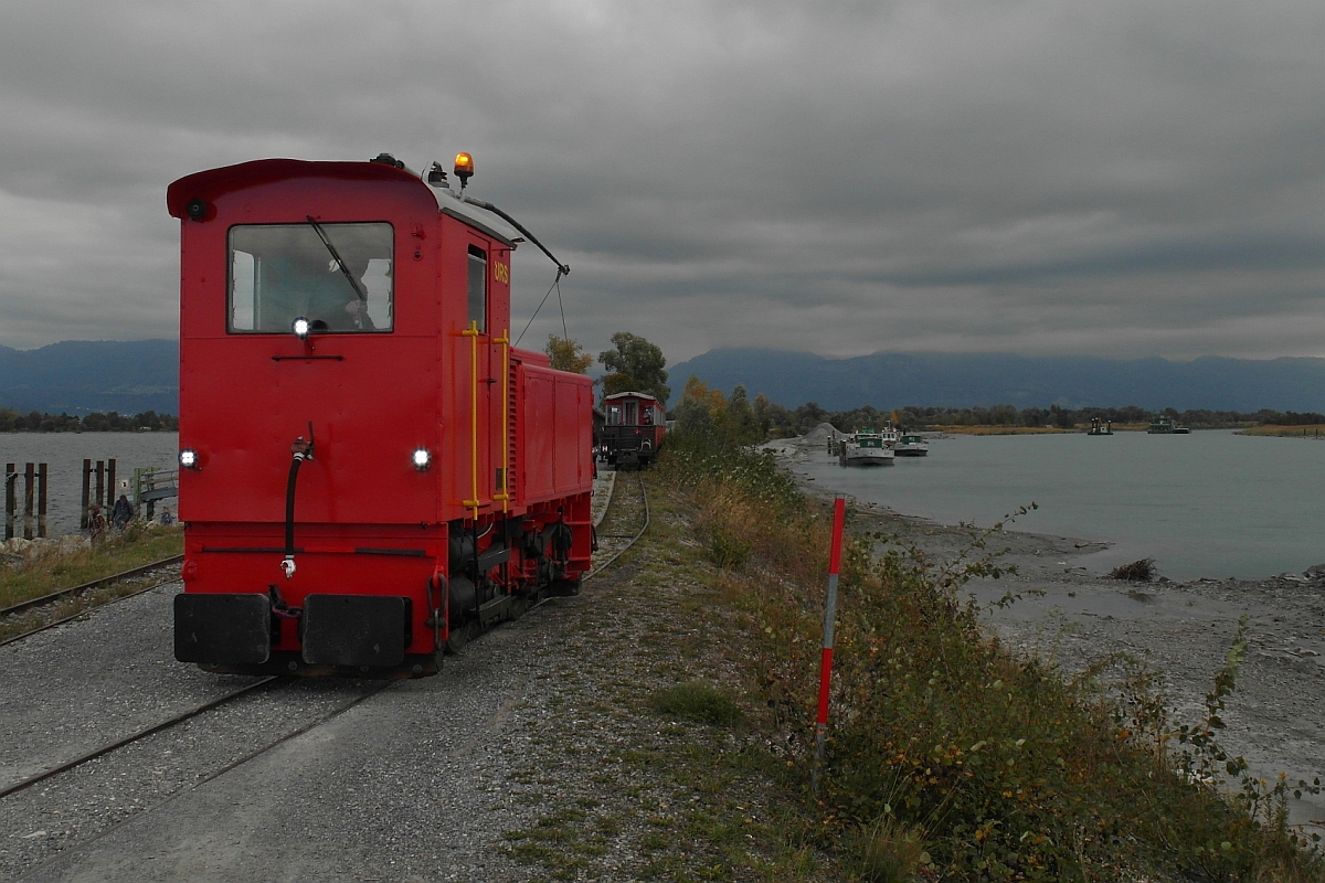 Nachdem die 1950 von der IRR (Internationale Rheinregulierung) in Betrieb genommene, von der Firma Ernst Stadler Elektro-Fahrzeuge Zürich gebaute elektrische/diesel-elektrische Lok die Fahrgäste von Lustenau zum Ziel, dem Rheindamm bei Hard gezogen hatte, wurde abgekuppelt, um den Zug zu umfahren. Auf dem Bild vom 11.10.2015 ist links der Bodensee und rechts der Rhein zu sehen. Die Fahrten zur Rheinmündung bietet der Verein 'Rhein-Schauen' an, der sich dafür einsetzt, das historische Jahrhundertbauwerk 'Rheinregulierung' und seine Zukunft durch das Museum und das Rheinbähnle im Bewusstsein der Bevölkerung zu erhalten. Infos unter www.rheinschauen.at.