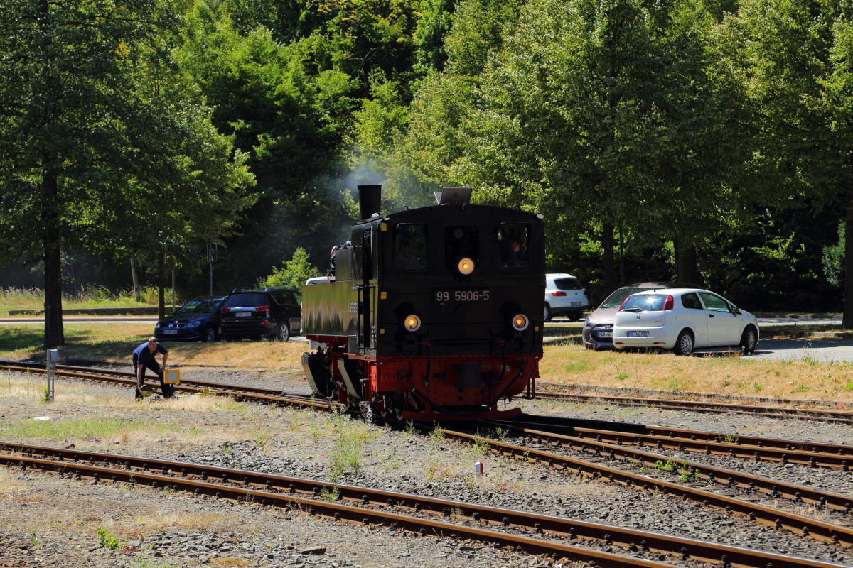 Nachdem 99 5906 am 07.07.2018 im Bahnhof Alexisbad auf Gleis 2 umgesetzt hat, um ihren Jubiläumssonderzug für die Rückfahrt nach Nordhausen zu übernehmen, wird vom Heizer, während die Lok wartet, die Weiche wieder für den Planverkehr zurückgestellt.