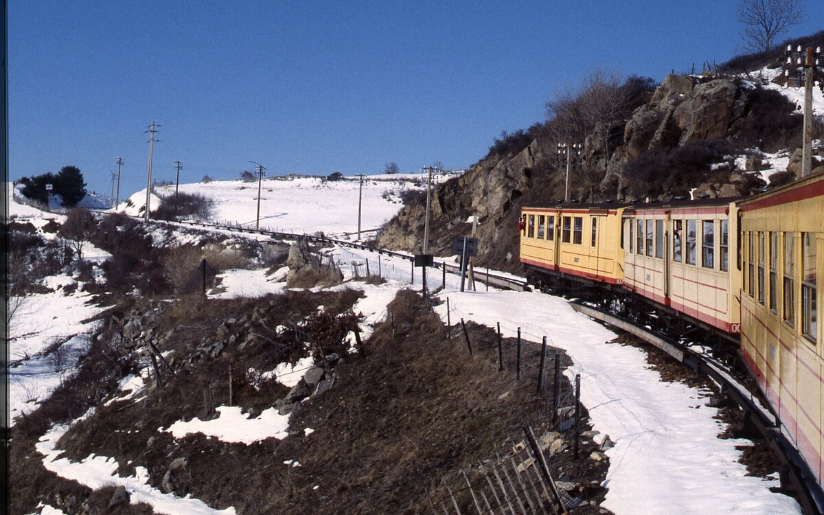 Nachdem bei uns mal wieder kein Schnee liegt, muss der Griff ins Archiv helfen: Im Februar 1996 ist der Petit train jaune von Villefranche-Vernet-les-Bains hinauf nach Latour-de-Carol-Enveitg in den Pyrenäen unterwegs, vorne der Z 117. Gut erkennbar die 850 V-Stromschiene.