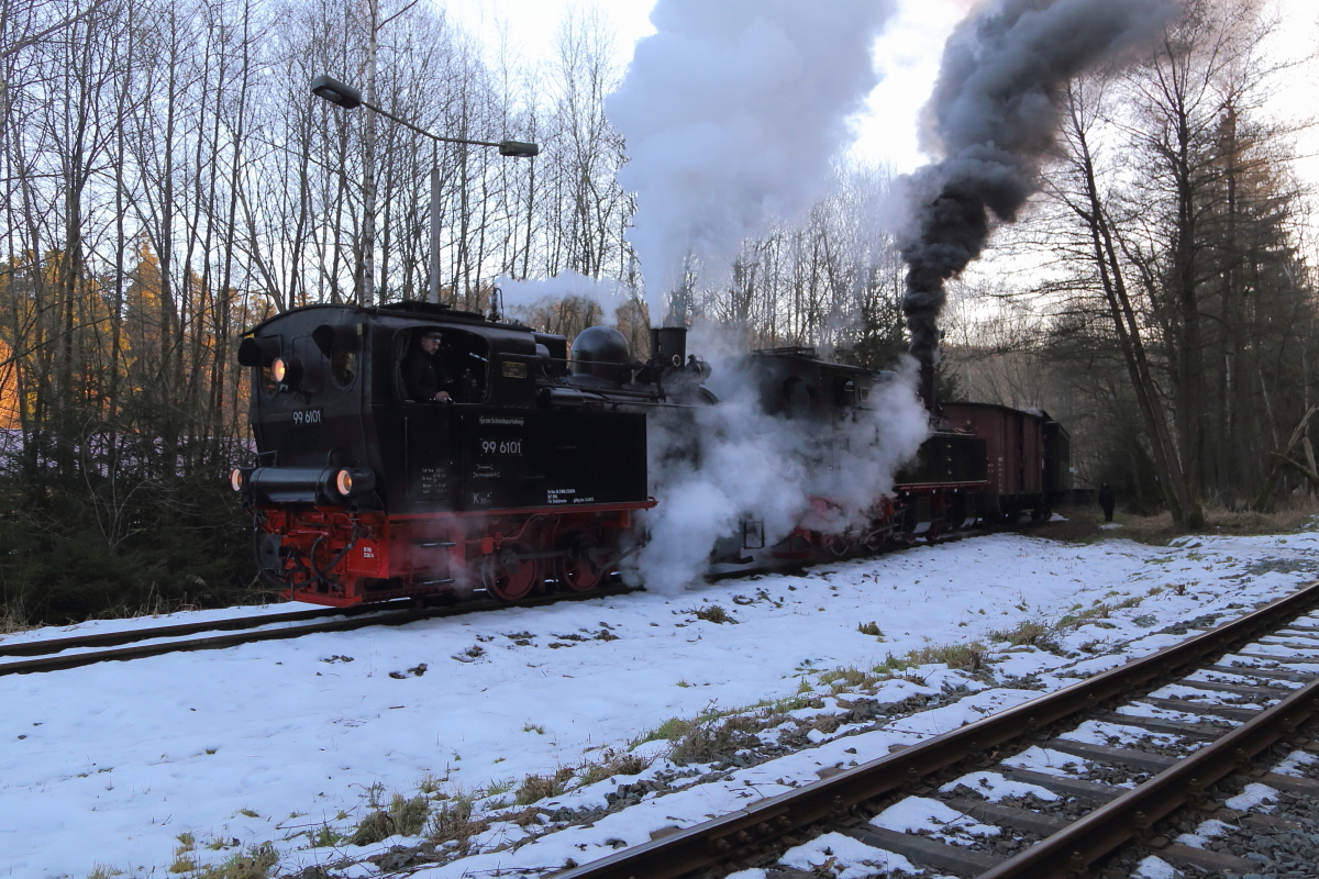 Nachdem ein Plantriebwagen passiert hat, ziehen 99 6101 und 99 5901 ihren IG HSB-Sonder-PmG, am späten Nachmittag des 14.02.2015, aus dem Anschlußgleis vom ehemaligen Heizwerk des einstigen VEB`s Siberhütte, um ihn für die Weiterfahrt nach Gernrode am Bahnsteig bereitzustellen. 