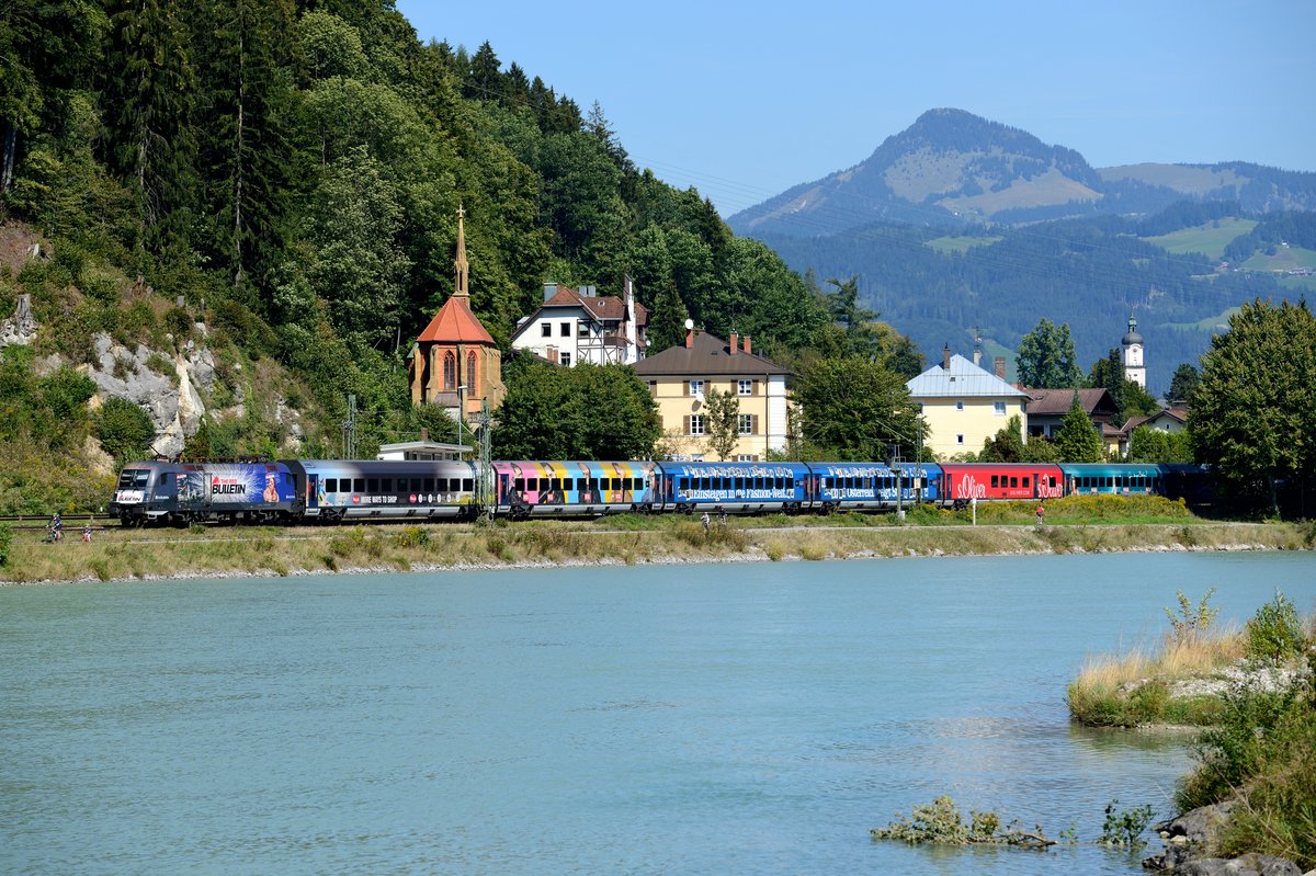 Nachdem inzwischen die Entkebung von Wagen und Lok stattgefunden hat, ein Erinnerungsbild an die 1116.248 mit Red Bulletin Werbung und der RailJet Garnitur 48 in der Ausführung als  The Red Bulletin Fashion Train . Am 12. September 2015 passiert der farbenfrohe Zug gerade als RJ 563 zum Flughafen Wien Bahnhof die Staatsgrenze bei Kiefersfelden. Der als doppelte RailJet Garnitur geführte Zug wurde im ersten Zugteil passenderweise von 1116.222 traktioniert, die ebenfalls für den Energie Drink Hersteller aus Fuschl am See wirbt. Motivvariante mit mehr Tele....