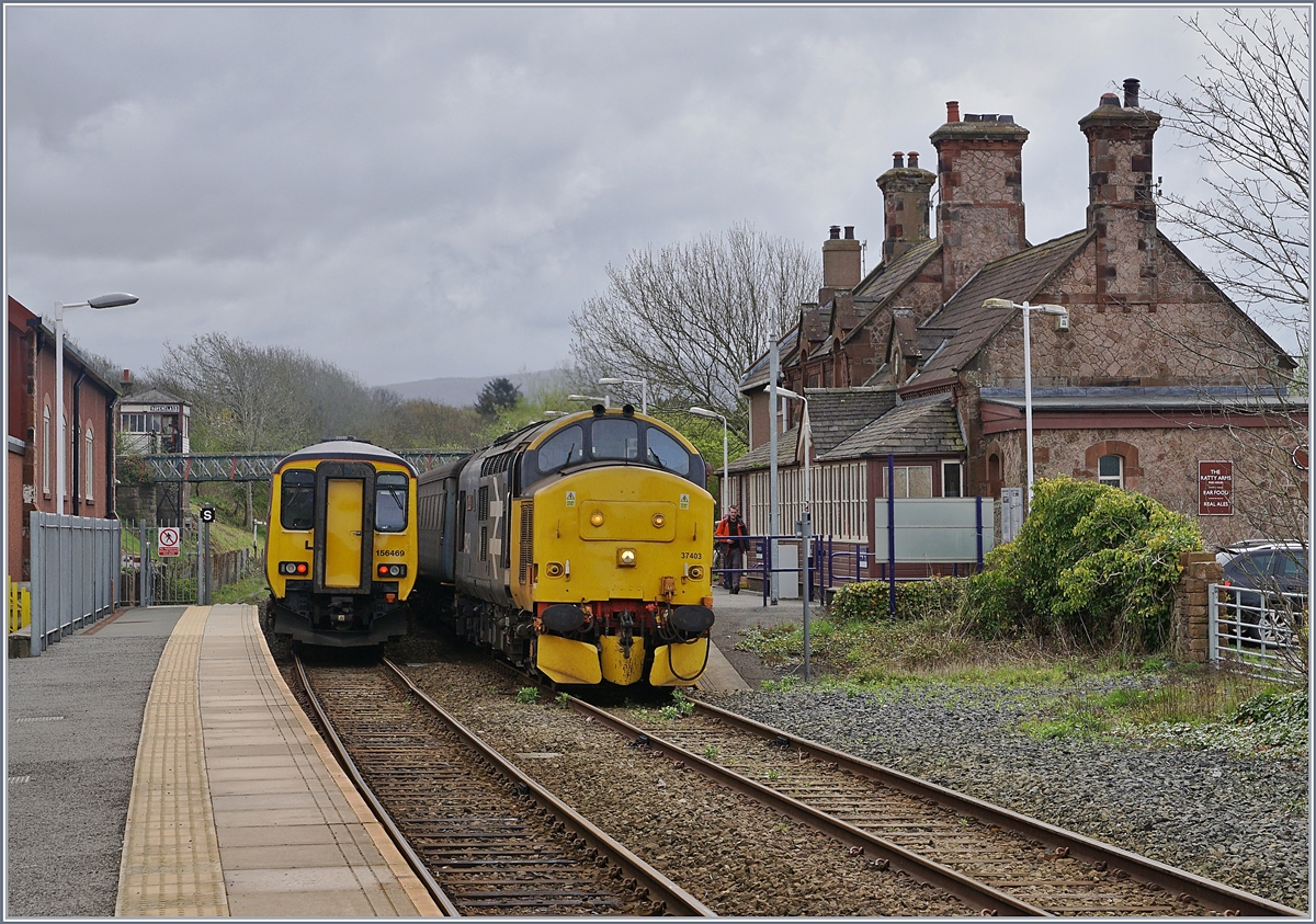 Nachdem der Northern Dieseltriebzug 156 469 in Ravenglass abgefahren ist, zeigt sich die 37 403 mit ihrem Nothern Regionalzug von Barrow-in-Furness (11:40) nach Carlisle (14:26) bei ihrem Halt vor dem schmucken Stationsgebäude von Ravenglass.
27. April 2018