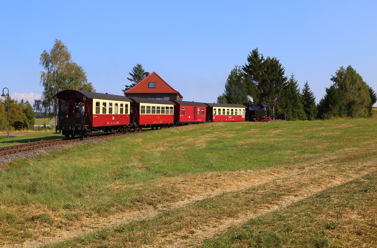 Nachdem P 8967 (Hasselfelde-Eisfelder Talmühle), gezogen von 99 6001, am späten Nachmittag des 31.08.2019 den Bahnhof Hasselfelde verlassen hat, passiert er jetzt in zügiger Fahrt die Ortsgrenze und strebt seinem nächsten Halt, Stiege, entgegen.