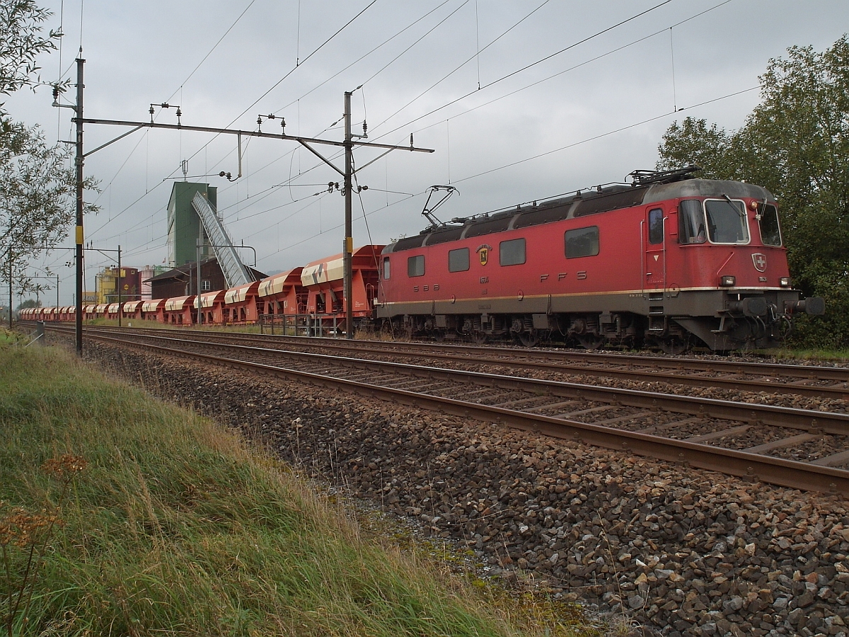 Nachdem Re 6/6 'AARBURG-OFTRINGEN' die befllten Holcim-Wagen vom Typ Faccns an die Entladestelle des Kieswerks von Brglen (TG) geschoben hatte, begann die wagenweise Entladung. Nachdem ein Wagen entleert war, fuhr die Re 6/6 eine Wagenlnge vor, damit der nchste Wagen entleert werden konnte (03.10.2014).