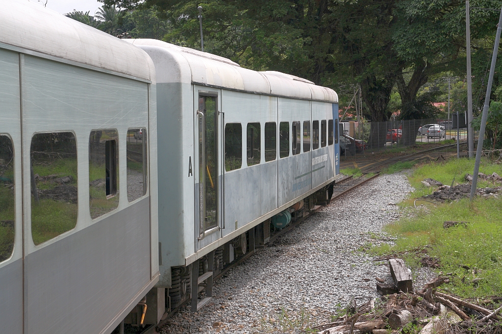Nachdem in der Stesen Sembulan (ehemals Sekretariat) für einen 4-teiligen Triebwagen der Bahnsteig zu kurz ist ragen die letzten eineinhalb Wagen über diesen hinaus. Die Reisenden dieser Wagen müssen halt innen bis zur nächsten Türe mit Bahnsteig durchgehen. - Blick vom Bahnsteigende auf den JKNS 8901-2 als letztes Fahrzeug des PU 506 (Beaufort - Sembulan) am 09.Februar 2025.