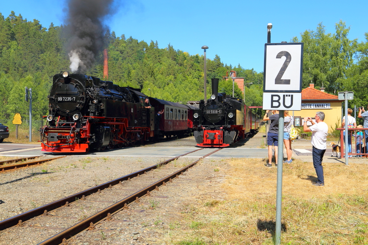 Nachdem das Treffen der beiden Züge am 07.07.2018 im Haltepunkt Silberhütte etliche schaulustige Urlauber angelockt hat, verläßt nun 99 7235 mit P8965 unter dem Klicken zahlreicher Fotoapparate das Örtchen in Richtung Hasselfelde, während 99 5906 mit ihrem Sonderzug vorerst noch im Haltepunkt verbleibt.