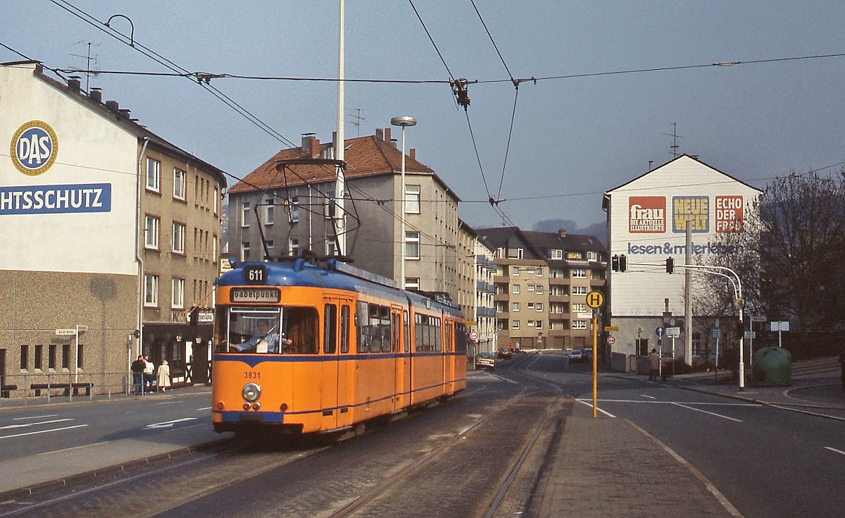 Nachdem zwei ex-Dortmunder Triebwagen ausgemustert werden mussten, beschafften die Wuppertaler Stadtwerke aus Karlsruhe den früheren Dortmunder Tw 48, der unter der Nummer 3831 eingereiht wurde. Er erhielt die in den letzten Jahren der Wuppertaler Straßenbahn übliche orange-blaue Lackierung. Hier erreicht er um 1984 nach der Fahrt durch die Wendeschleife in der Lenneper Straße die Haltestelle Walterstraße in Heckinghausen.