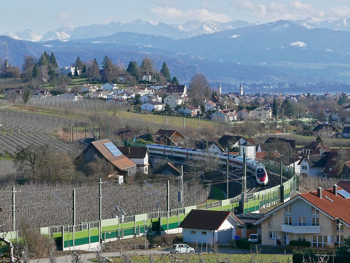 Nachher# - Elektrotriebzug und Lrmschutzwnde in Bodolz. Nach der Elektrifizierung und der damit verbundenen Aufstellung von Lrmschutzwnden hat sich die Anzahl der mglichen Fotostellen an den Gleisbgen in und bei Bodolz verringert. Vom Herrmannsberg wurde der von Zrich nach Mnchen fahrende ECE 193 am 17.02.2021 fotografiert.