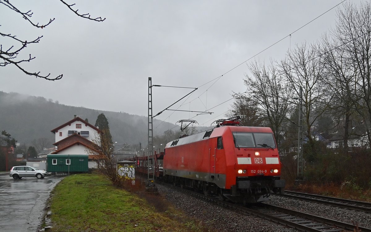 Nachschub an Autotransportwagen fürs Audiwerk hat die 152 094-9 am Haken als sie hier durch Neckargerach gen Binau unterwegs ist am Mittag des 3.2.2021