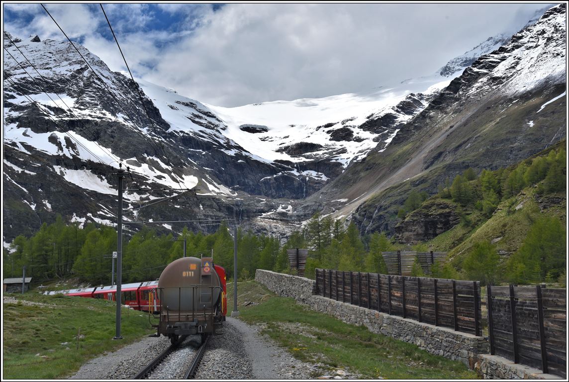 Nachschuss auf R1633 nach Campocologno oberhalb Alp Grüm mit dem schwindenden Palugletscher im Hintergrund. Verschiedene Holzbauten verhindern Schneeverwehungen während der Wintermonate. (09.06.2020)