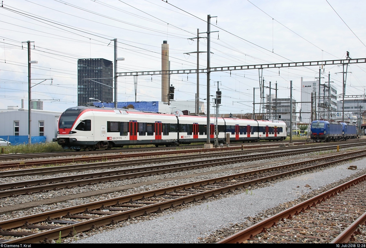 Nachschuss auf RABe 523 047 (Stadler FLIRT) der Regio-S-Bahn Basel (SBB) als S1 von Basel SBB (CH) nach Frick (CH), die den Bahnhof Pratteln (CH) erreicht.
Aufgenommen von der Güterstrasse.
[10.7.2018 | 12:28 Uhr]