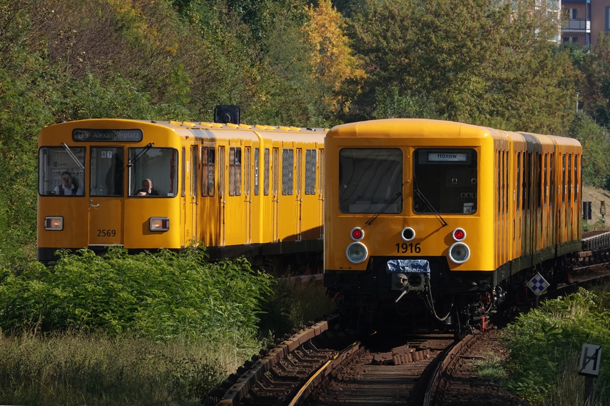 Nachschuss auf den restaurierten Zug Typ E III bei der Ausfahrt aus dem Bhf. Hellersdorf. Auf dem Gegengleis ein Zug des Typ F. (30.09.2017)
