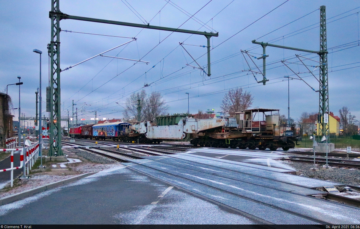 Nachschuss auf den Trafozug von Probstzella, der in Halle (Saale), Karl-von-Thielen-Straße, auf dem Weg zur Zugbildungsanlage (ZBA) Halle (Saale) seinem Ziel entgegenrollt. Von dort aus erfolgt im Laufe des Tages die Zustellung zum ABB Trafowerk Halle (Saale) über dessen Anschlussbahn.
Hier ist der  Tausendfüßer  - ein Tiefladewagen der Gattung  Uaai <sup>831</sup>  - mit dem Trafo noch einmal in ganzer Länge zu erkennen.
Das Foto entstand hinter dem Bü.

🧰 Spedition Kübler GmbH
🕓 6.4.2021 | 6:36 Uhr